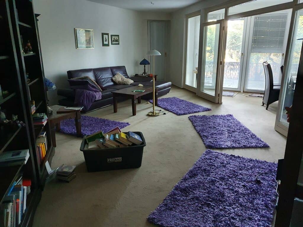 Wohnzimmer mit Schränken, Teppichen und Büchern in Berlin-Charlottenburg als Teil einer Haushaltsauflösung, welches entrümpelt wird