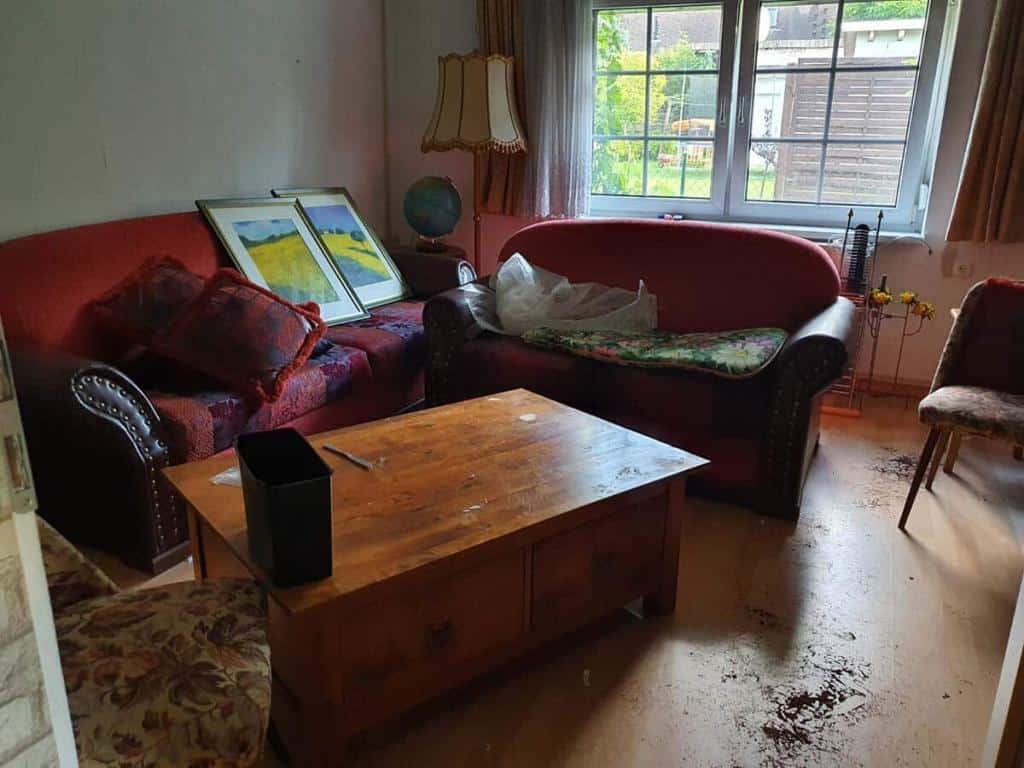 Wohnzimmer eines Hauses in Berlin Brandenburg mit Couch, Schrank und Sofa vor einer Entrümpelung