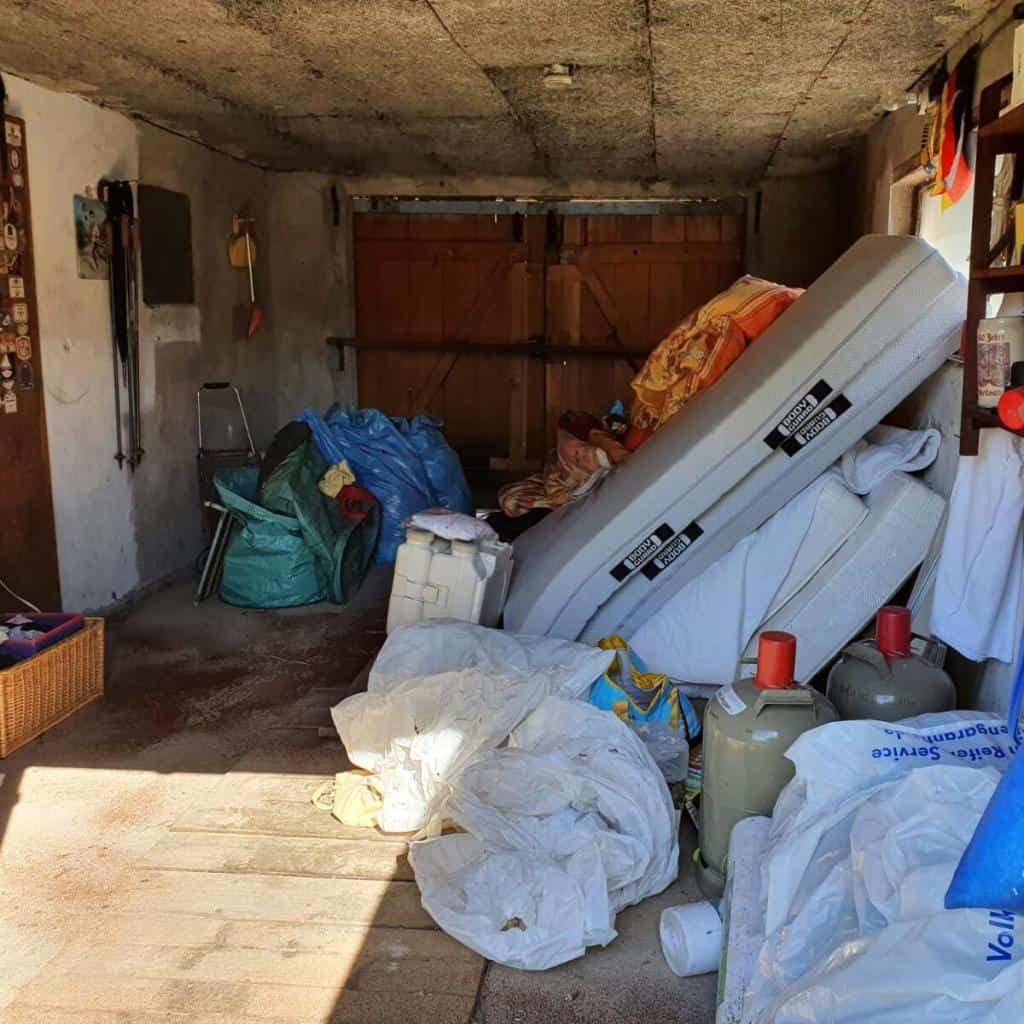 Zugemüllte Garage mit Abfällen vor einer Entrümpelung in Berlin-Brandenburg für Entrümpelung fertig